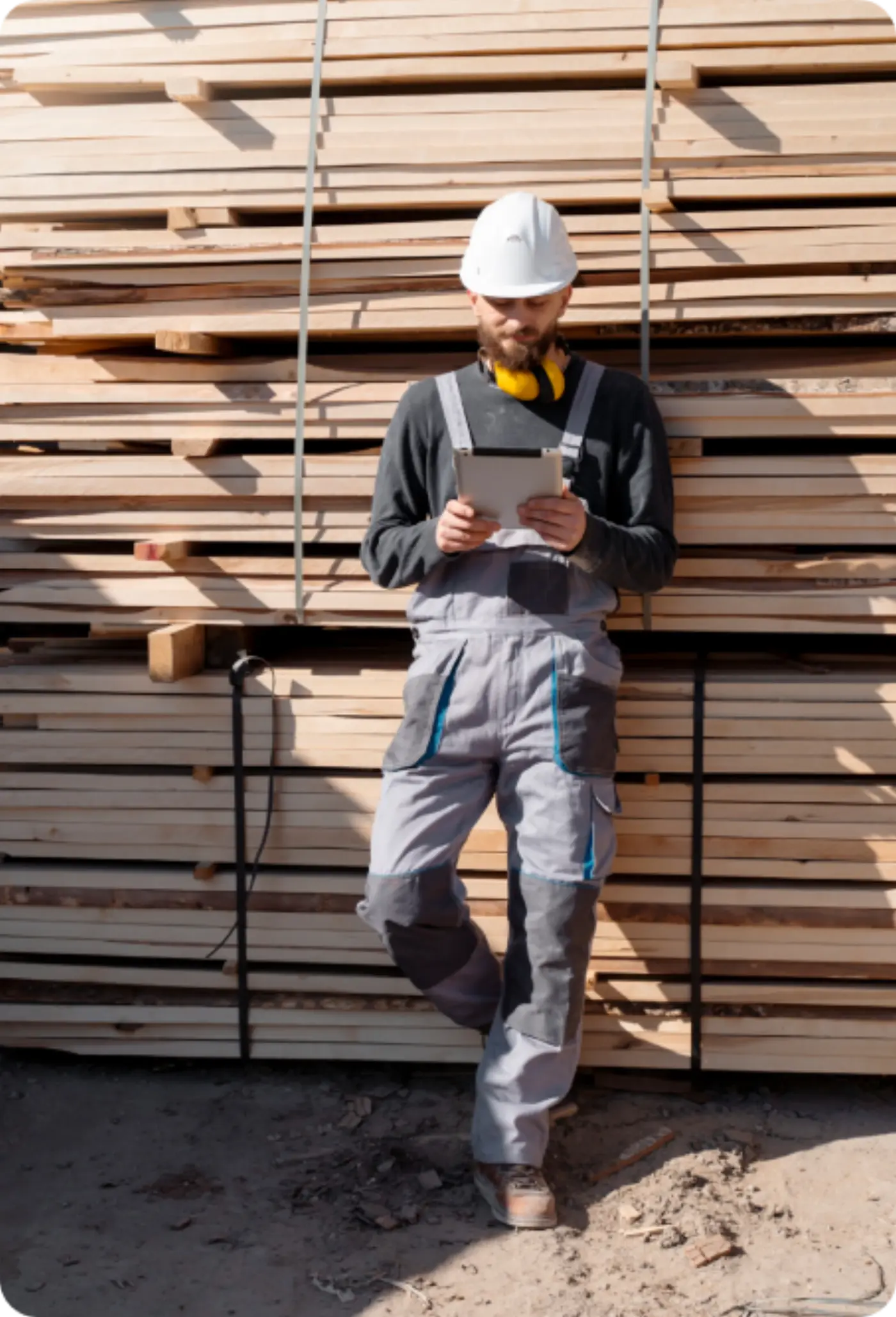 Worker checking stock in a timber yard