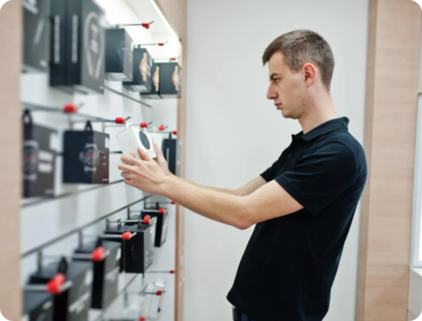 Staff member handling boxed stock on a shop display wall