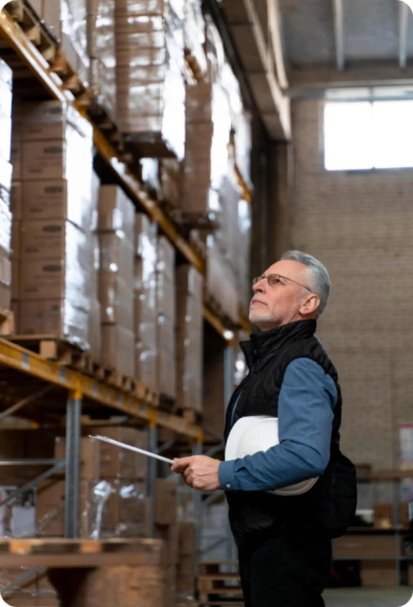 Tall warehouse racking stacked with shrink-wrapped pallets